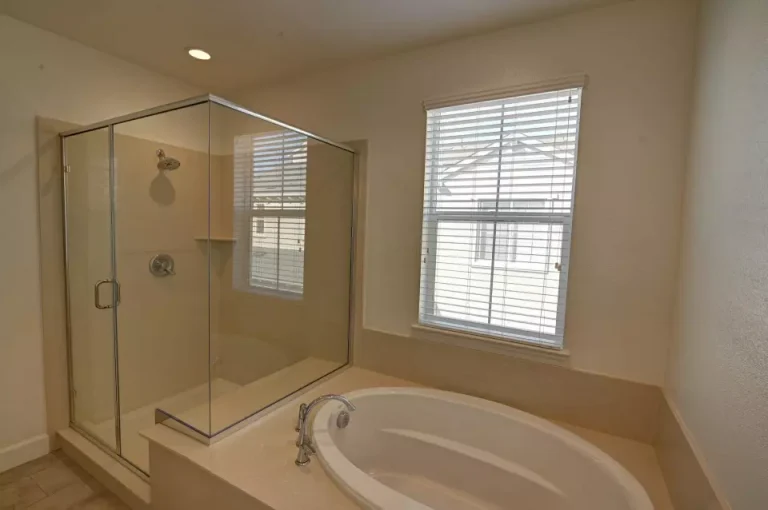 A glass shower stall and bathtub in a bathroom promoting a clean living space.
