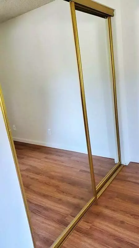 A gold mirrored closet in a Cupertino room.