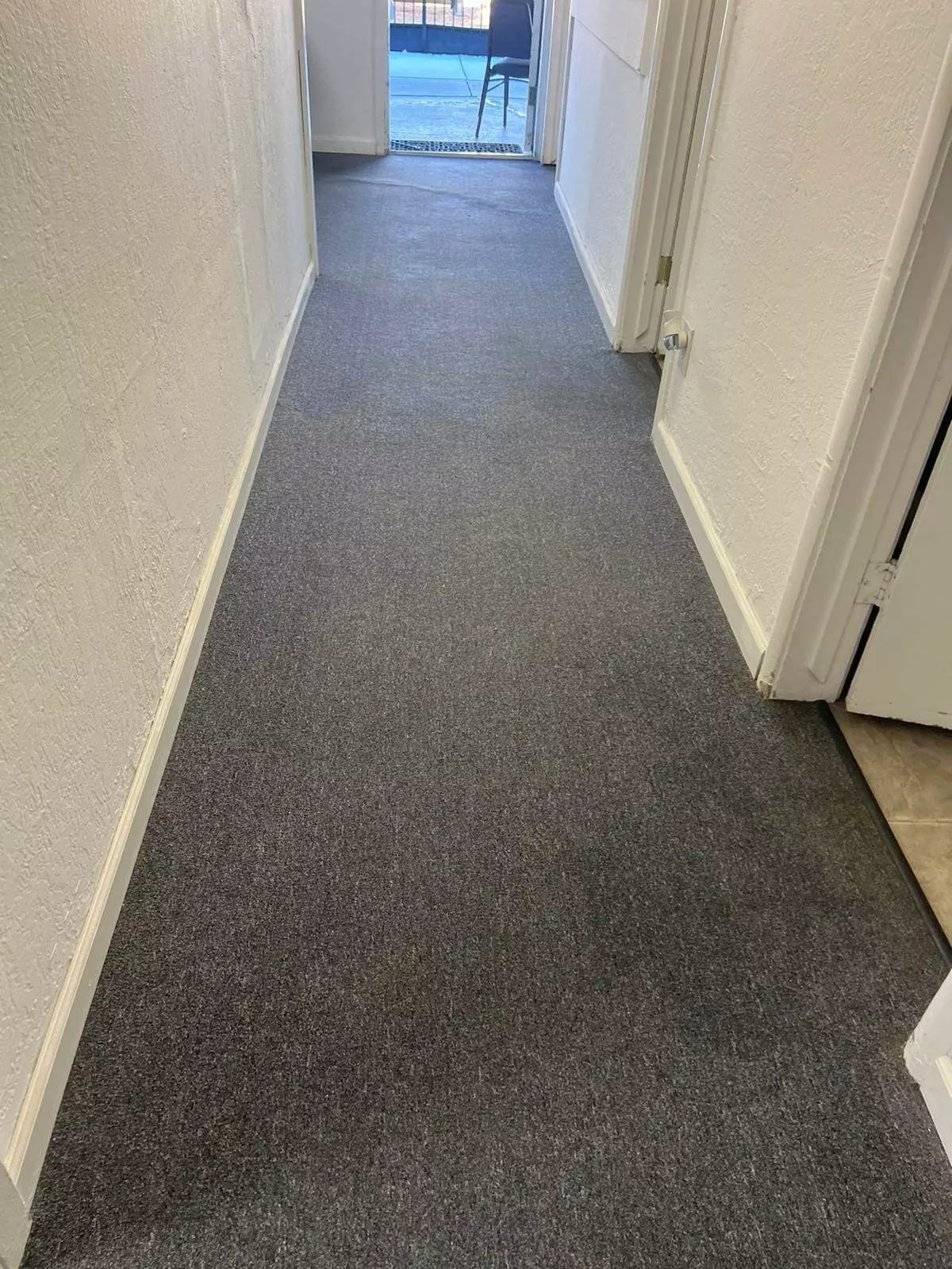 A carpeted hallway in need of professional cleaning.