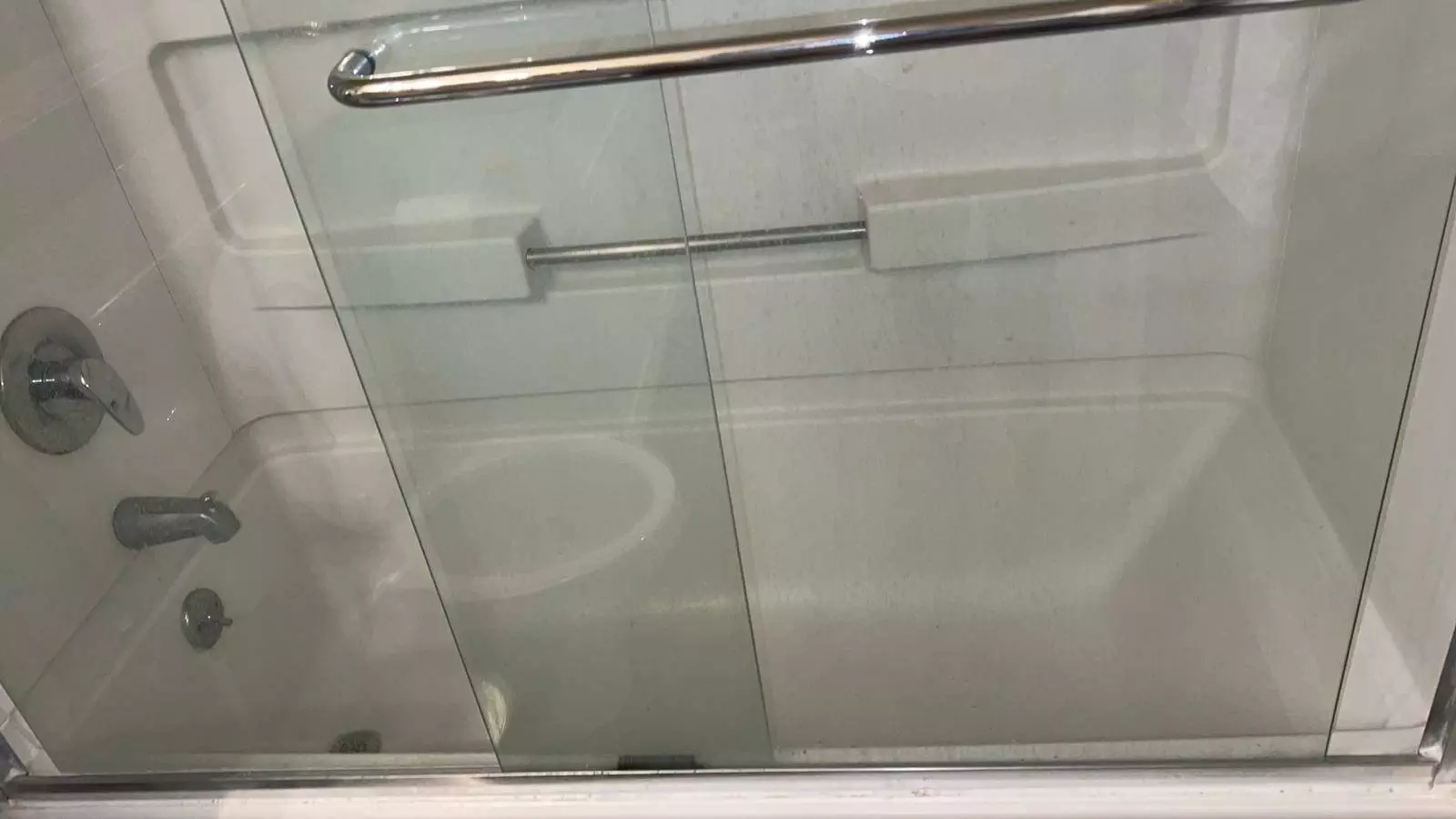 A bathroom with a glass shower door in a mid-term rental property under property management.