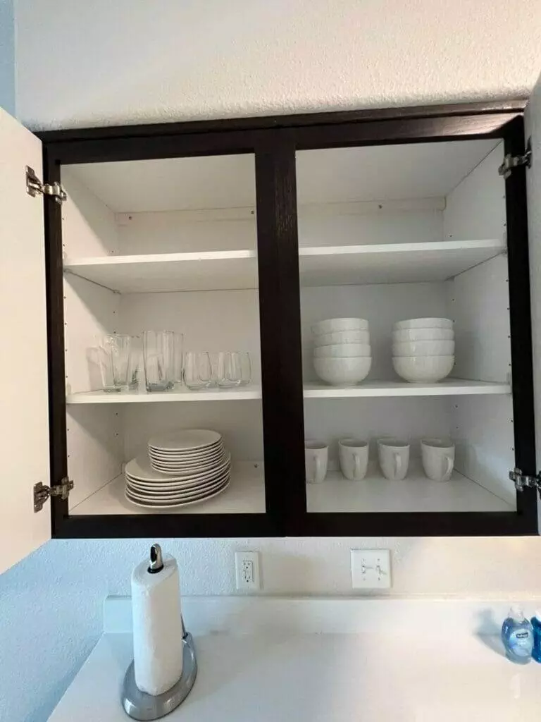 A kitchen cabinet with plates and dishes on it.