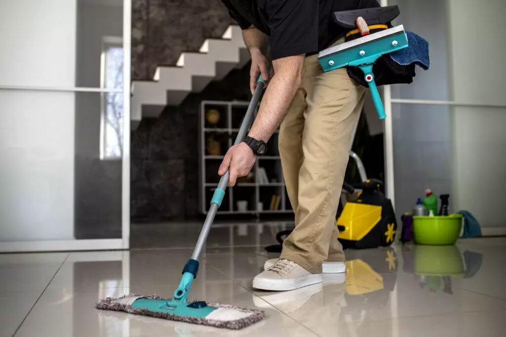 A man cleaning a floor with a mop in San Jose.