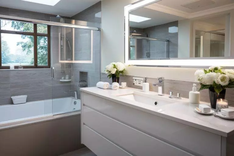 A white bathroom with a bathtub and sink available for Airbnb guests in Milpitas.