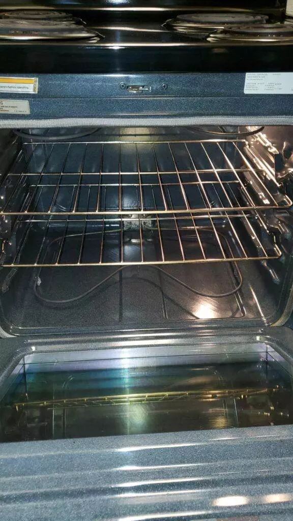 Interior of an open electric oven showing racks and a clean, unused appearance, maintained by San Jose Short Term Cleaning.