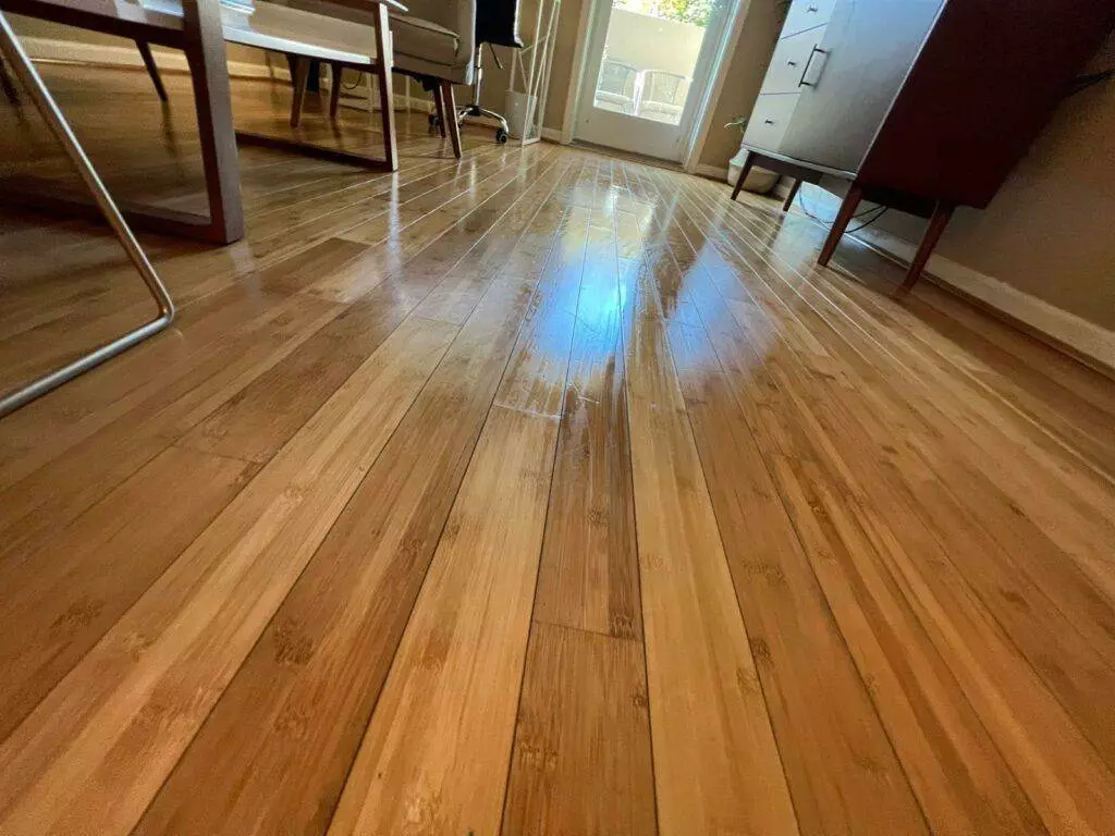 Sunlight streaming through a window, casting a bright blue pattern on a wooden floor in a room with furniture at Cupertino AirBNB.